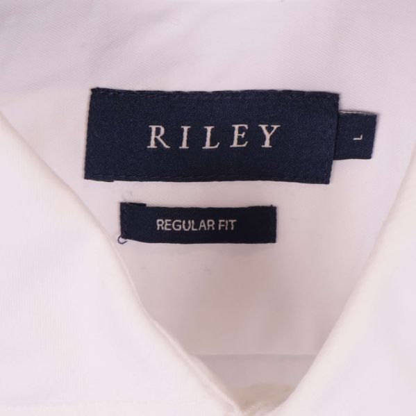 Närbild på Riley logotyp i nacken på vit skjorta