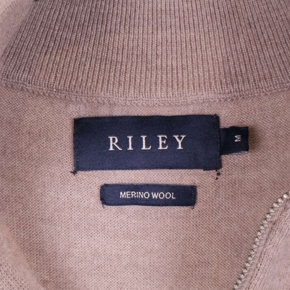 Närbild på RILEY-märkning och materiallapp merino wool