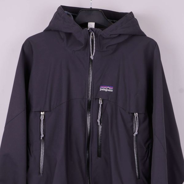 Närbild på jackans bröstparti med logotyp och dragkedjor