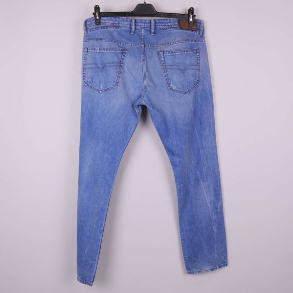 Baksidan av blå jeans med bakfickor och läderpatch