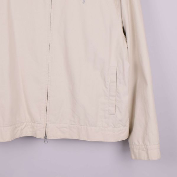 Midje- och ärmdetaljer på beige jacka 