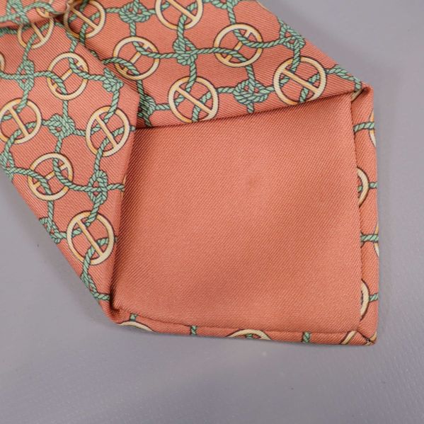 Detalj på spetsen av aprikosfärgad Hermès-slips