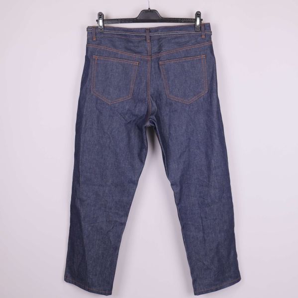 Jeans i mörk denim hängande på galge bakifrån