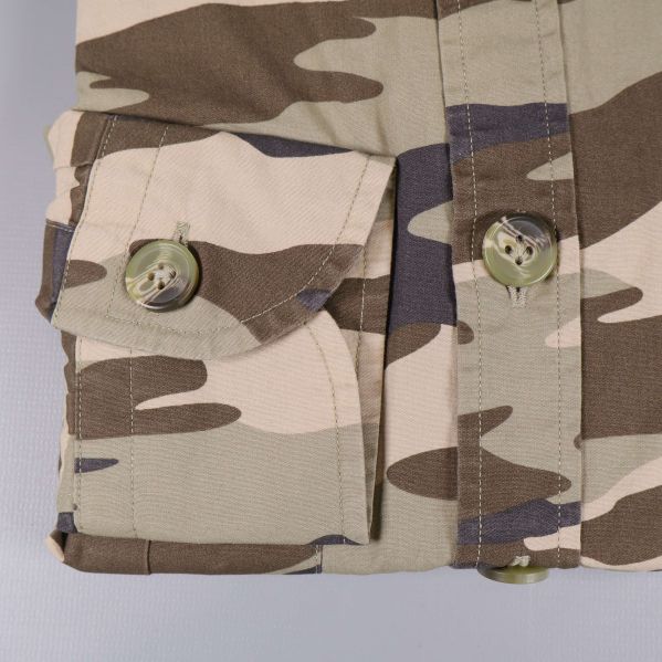 Närbild på manschett och knapp med camouflagemönster