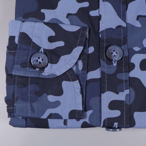 Närbild på skjortärm och manschett med camouflage och knappar