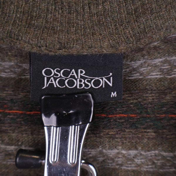 Oscar Jacobson etikett på grönstickad väst