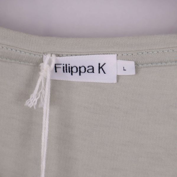 Närbild på halsringning med Filippa K etikett och storlek L