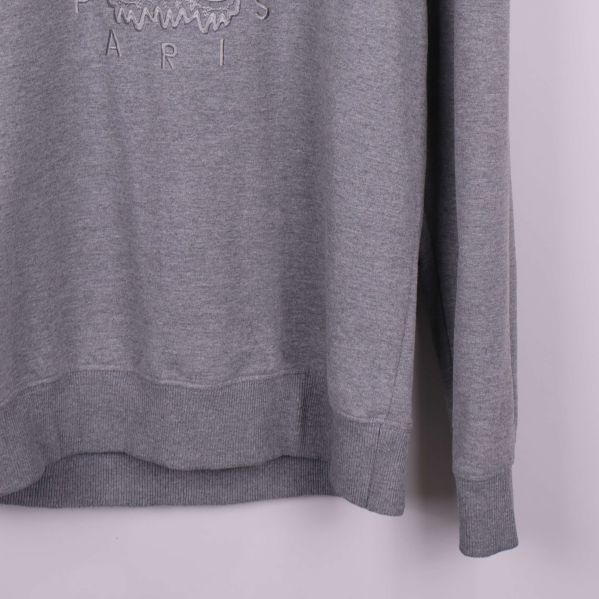 Ribbad mudd i ärmslut och nederkant av grå sweatshirt