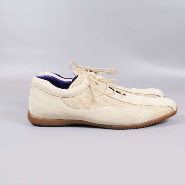 Sidan av beiga sneakers med låg profil