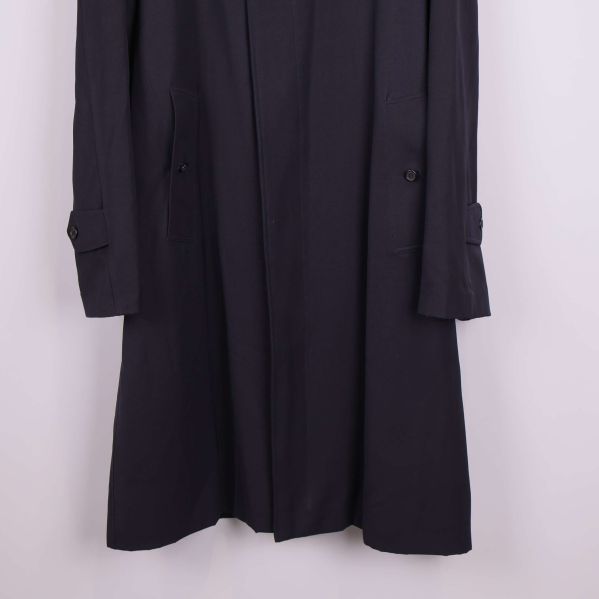 Närbild på ärmslut och fickdetaljer på trenchcoat