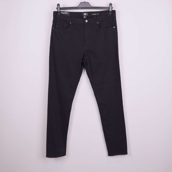 Framsidan av svarta skinny jeans på galge