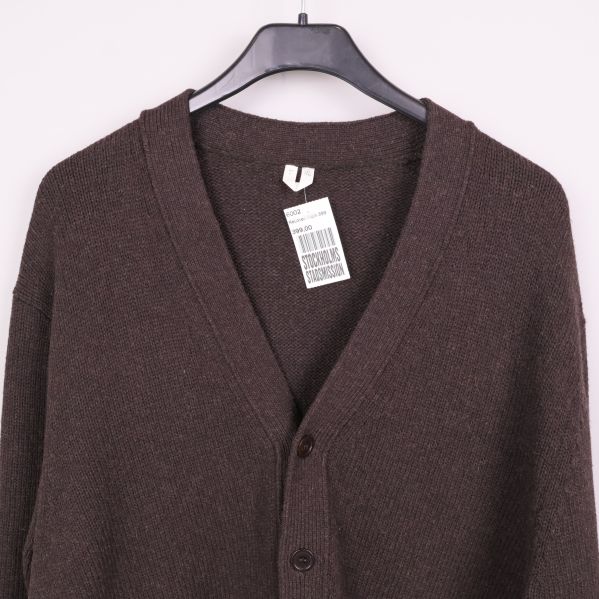 Närbild på etikett och halsringning på brun cardigan