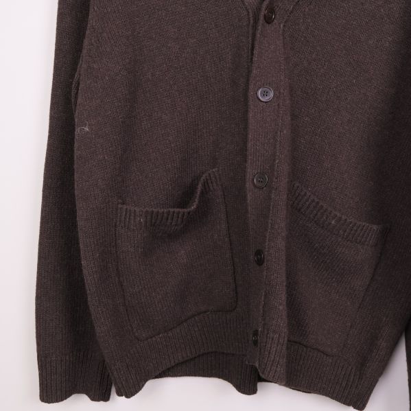 Stickad brun cardigan med fickor och knappar i närbild
