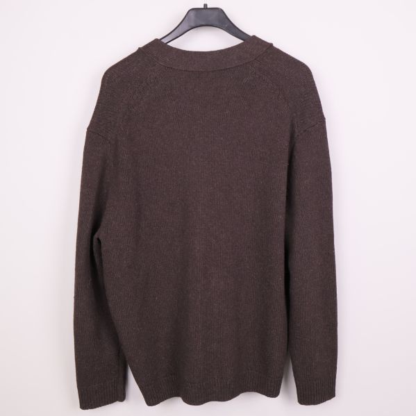 Baksidan av stickad brun cardigan på galge
