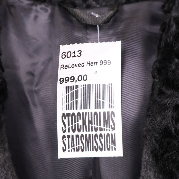 Prislapp från Stockholms Stadsmission i kappans krage
