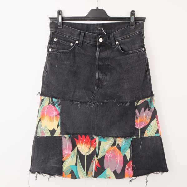 Framsida av svart denimkjol med färgglada blommiga inslag