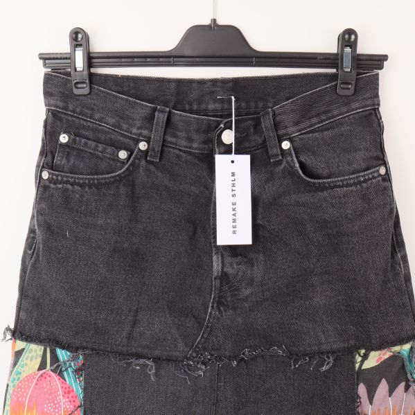 Närbild av kjolens denimdetaljer och etikett