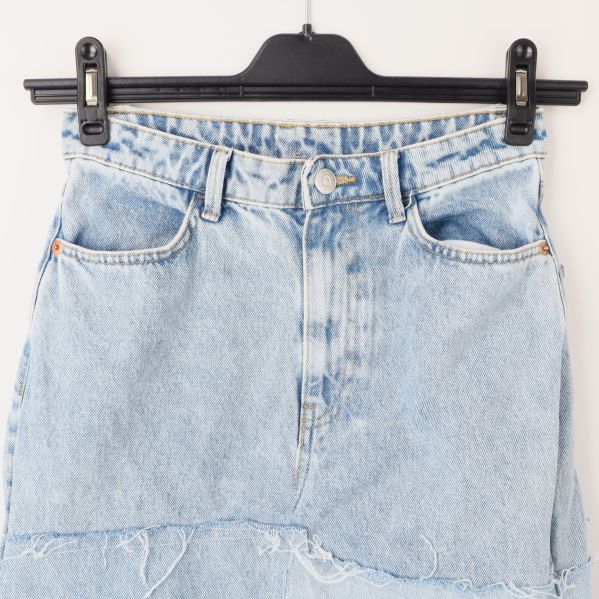 Närbild av framfickor på denimkjol