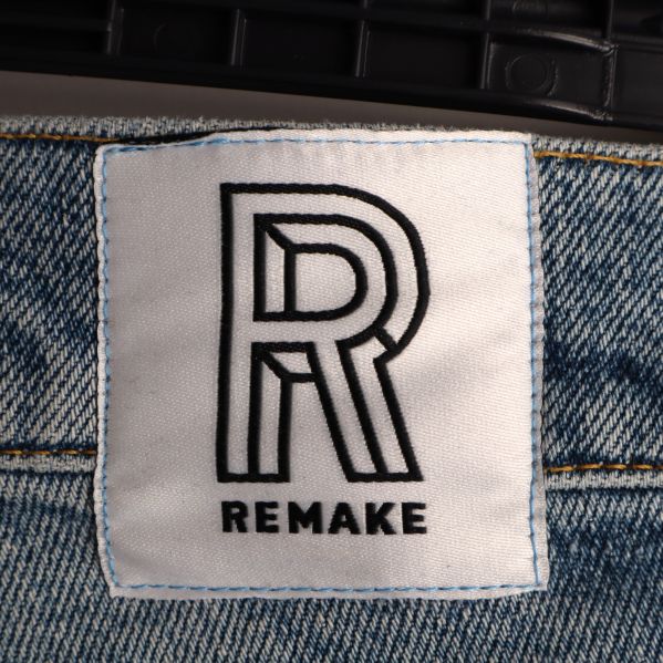 Närbild av Remake-märket på jeansen