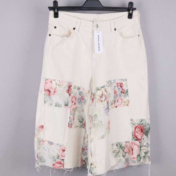 Framsida av vita bermudashorts med blommönster
