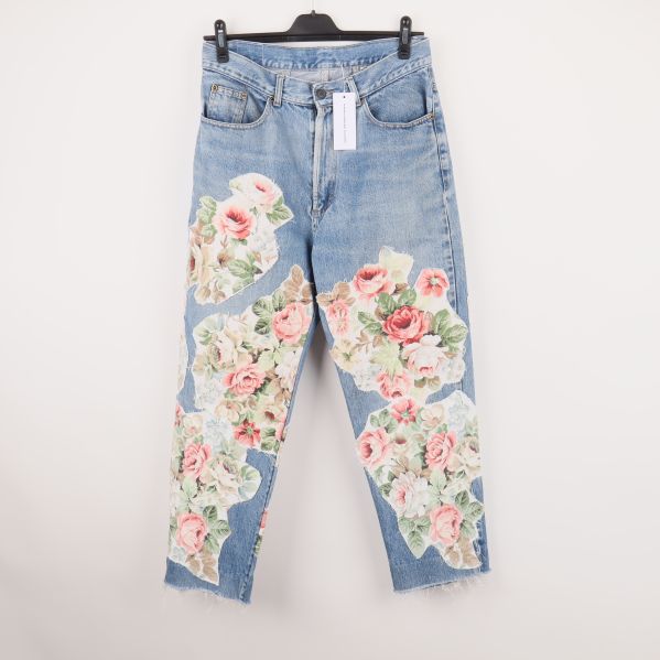 Framsidan av jeans med blommiga patchar