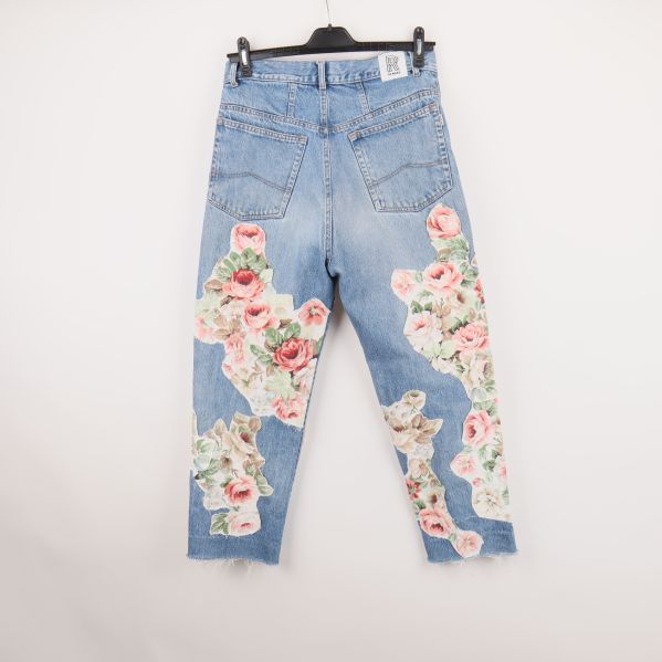 Baksidan av jeans med blommiga patchar