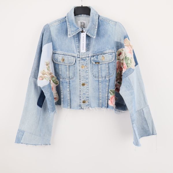 Framsida av denimjacka med blommiga patchar