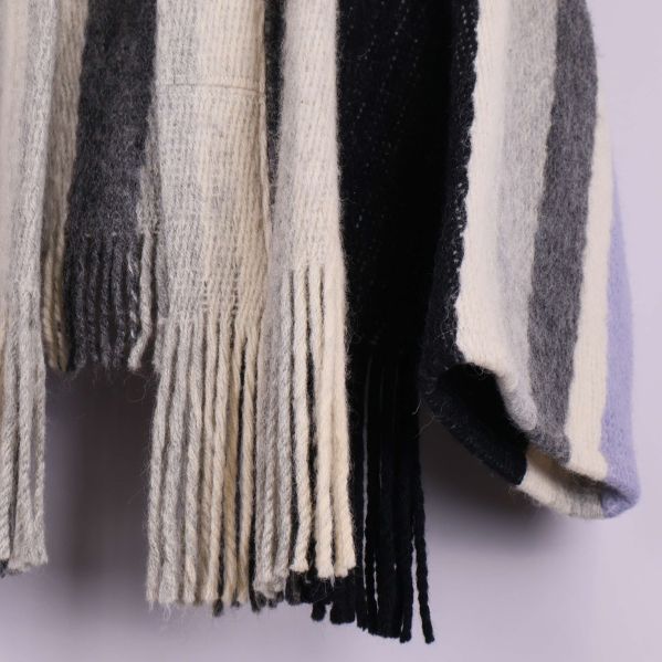 Närbild av fransdetaljer längst ner på cardigan