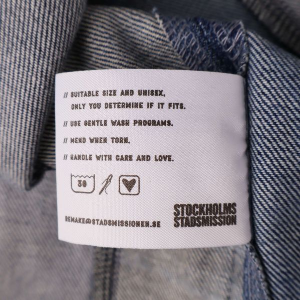 Omsorgsetikett med tvättråd och text på insidan