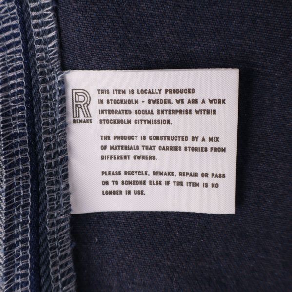 Vit etikett med information om produktion och material