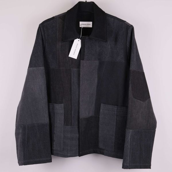 Framsida av svart patchwork denimjacka på galge