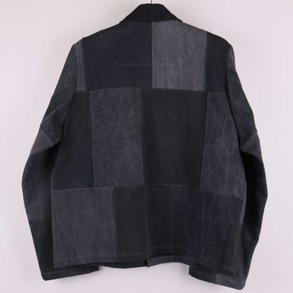 Baksida av svart denimjacka i patchworkstil