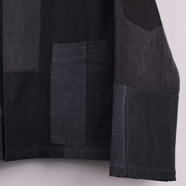 Närbild på ficka och tygstruktur på jackans framsida