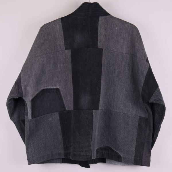 Baksida av jacka med geometriska denimlappar