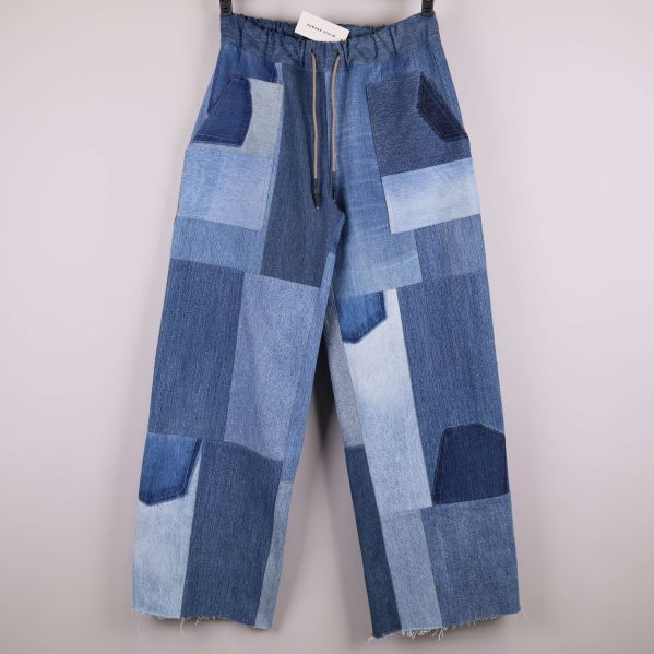 Framsidan av jeans med blå patchwork och resårmidja