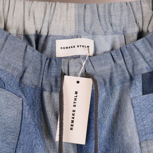 Närbild på resårmidja och etikett i denimbyxa