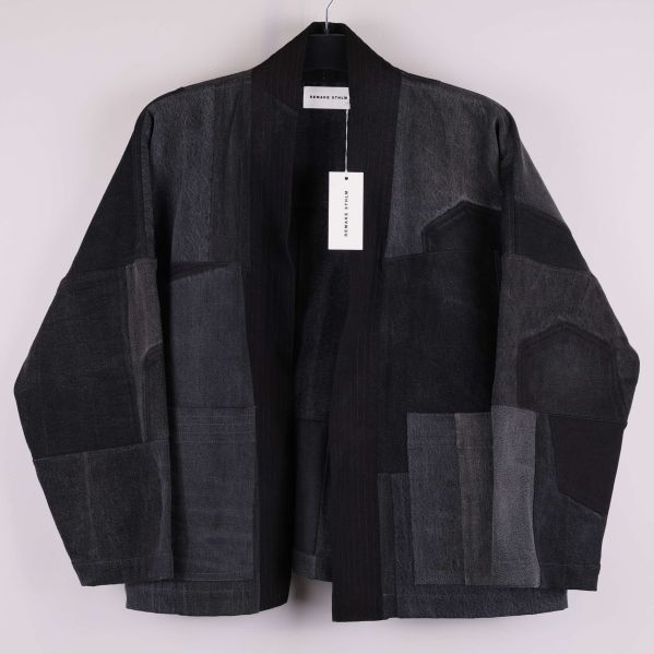 Kimonojacka i svart och grå patchwork hängande på galge