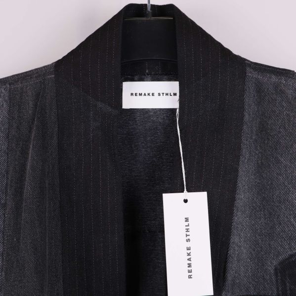 Närbild på kragen med Remake Sthlm-tag och etikett