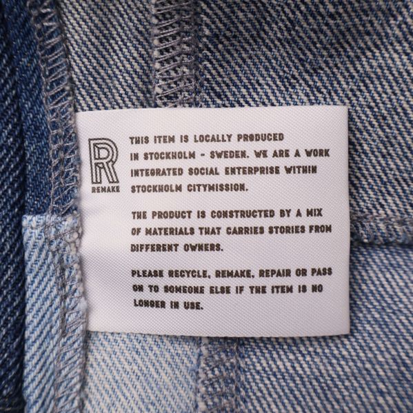 Invändig etikett med engelsk text om plagget och återbruk