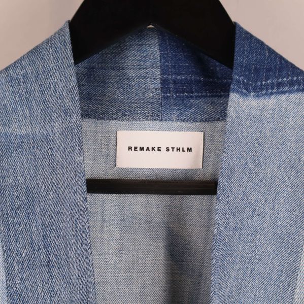 Närbild på denimkimono med Remake Sthlm etikett i nacken