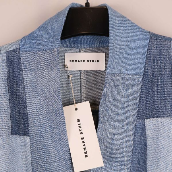 Detaljbild på jackans krage och etikett Remake Sthlm