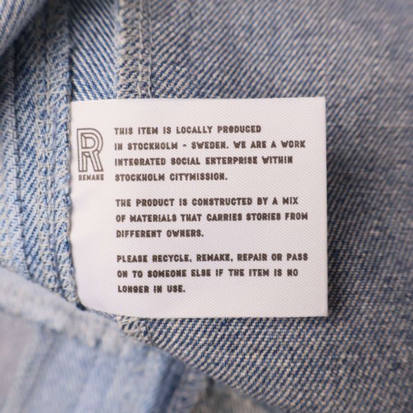 Vit etikett med engelsk text om lokal produktion och material