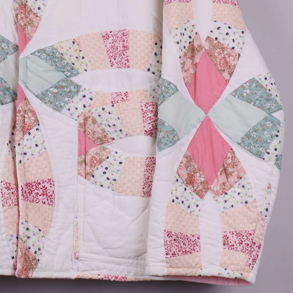 Detaljbild av quiltat tyg och ficka på jackan