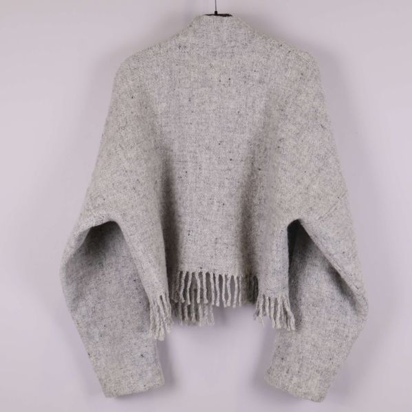 Baksidan av stickad jacka i ljusgrått med hängande ärmar