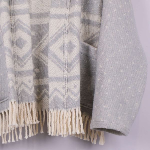 Närbild på nederkantens fransar och fickor på cardigan