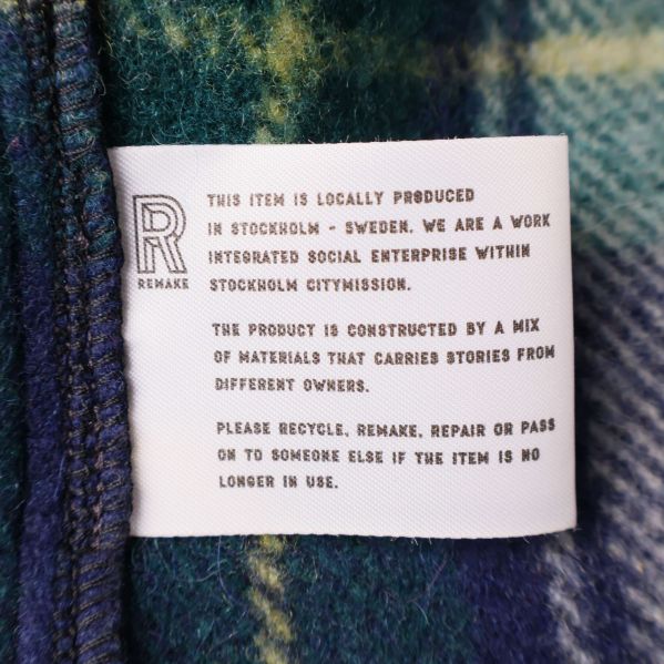 Textetikett om produktion och material på insidan av jackan