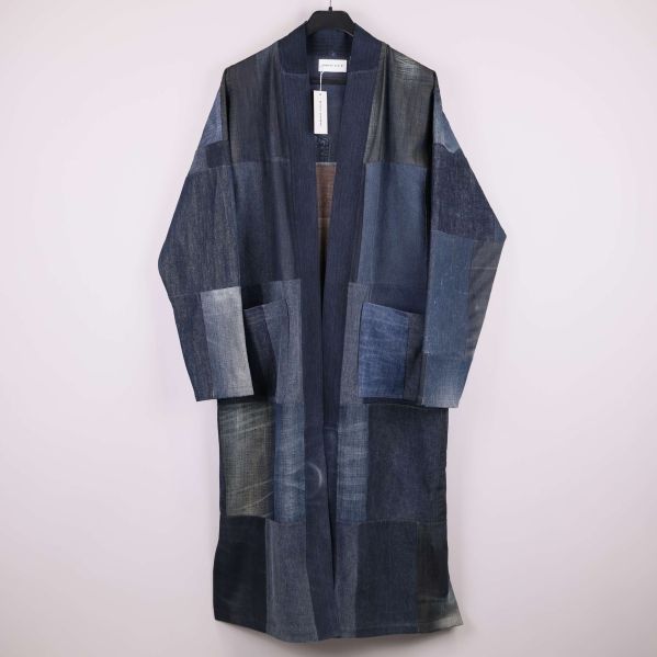 Lång patchwork rock i mörk denim upphängd på galge