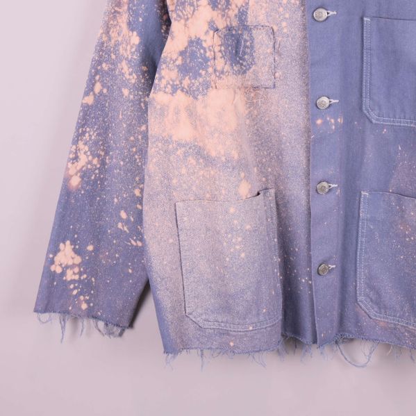 Nedre del av jacka visar fransiga kanter och färgstänk