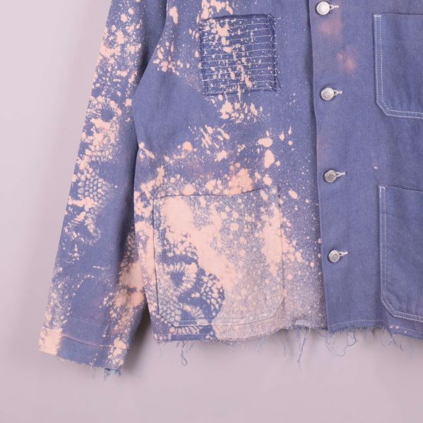 Nederdel av jackan visar fickor och slitna kanter