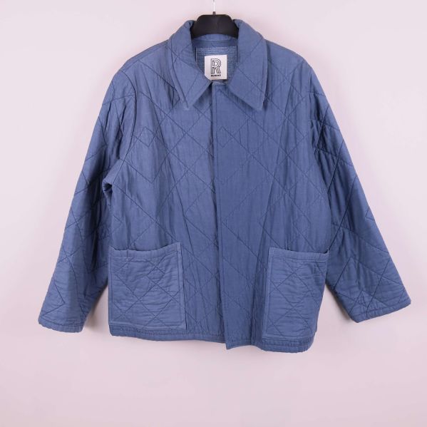 Helbild av blå quiltad jacka framifrån med fickor